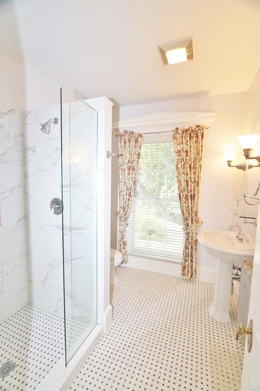 bathroom with toilet, baseboards, visible vents, and a marble finish shower