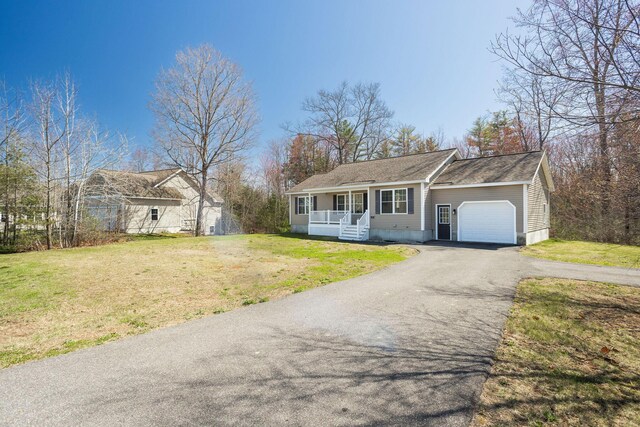 view of front of house featuring an attached garage, a porch, a front lawn, and aphalt driveway