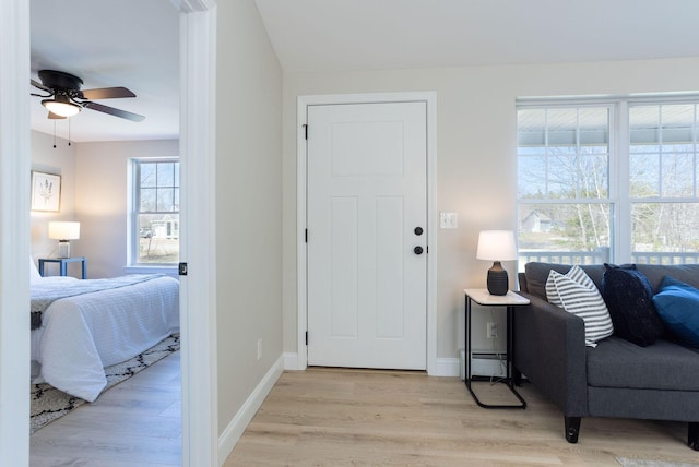 entrance foyer with light wood-style floors, baseboards, and ceiling fan