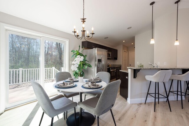 dining space featuring a chandelier and light wood-type flooring