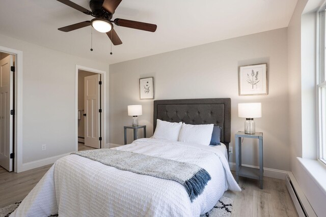 bedroom with a baseboard radiator, baseboards, a ceiling fan, and wood finished floors