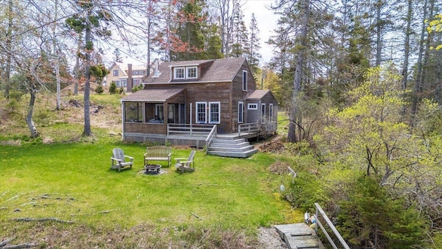 138 Hewes Point Rd, Islesboro, ME 04848 - view of front of home featuring an outdoor fire pit, a wooden deck, a front yard, a sunroom, and a shingled roof