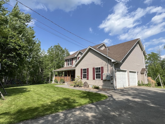 38 Dunston Dr, Glenburn, ME 04401 - traditional home with covered porch, asphalt driveway, a front lawn, roof with shingles, and an attached garage