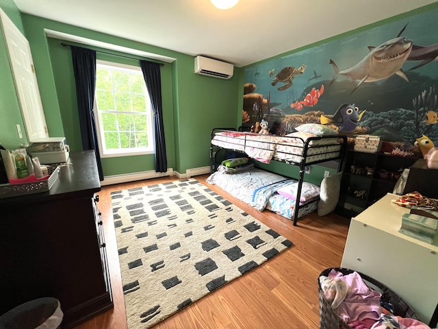 38 Dunston Dr, Glenburn, ME 04401 - bedroom featuring a wall mounted air conditioner, wood finished floors, and baseboard heating