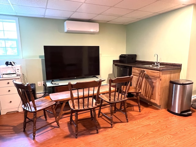 38 Dunston Dr, Glenburn, ME 04401 - dining space featuring a wall mounted AC, a drop ceiling, light wood-type flooring, baseboard heating, and bar with sink