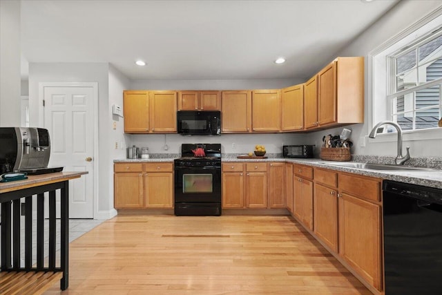 kitchen with black appliances, a sink, light wood-type flooring, light countertops, and recessed lighting