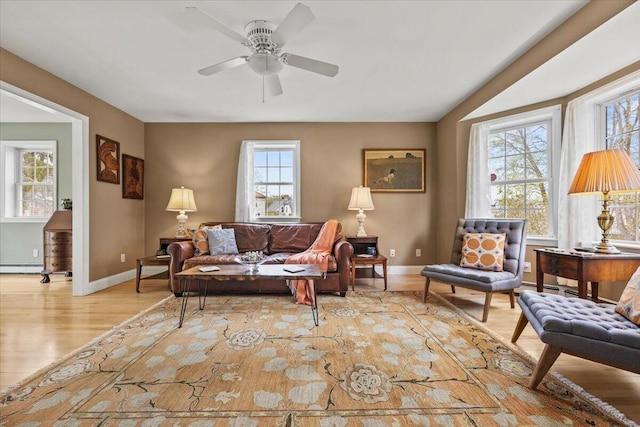 living room with plenty of natural light, wood finished floors, ceiling fan, and baseboards