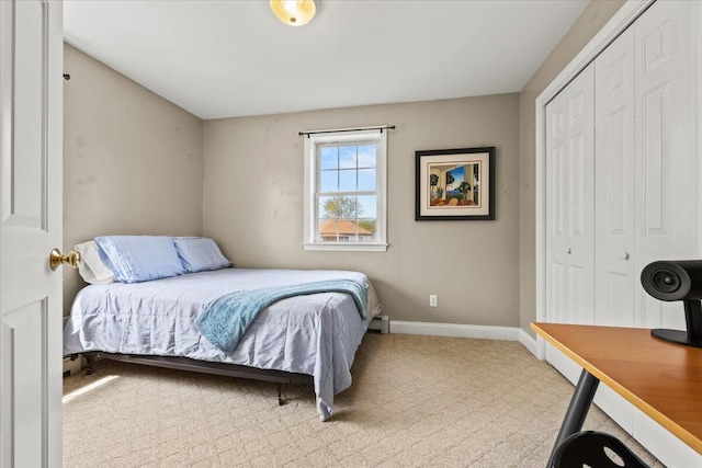 carpeted bedroom with a closet and baseboards