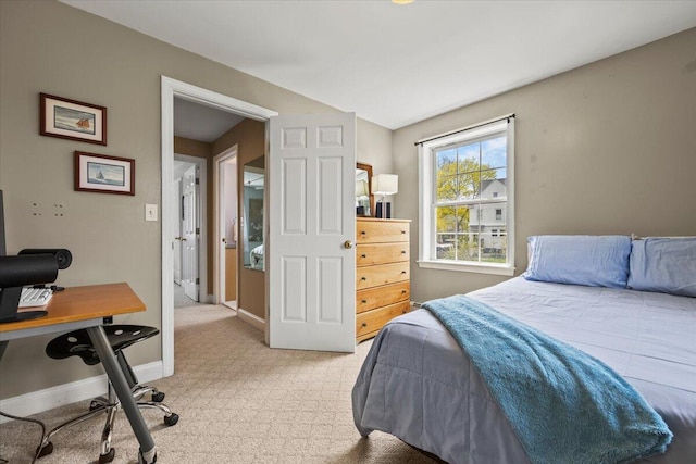 bedroom featuring light colored carpet, baseboards, and an office area