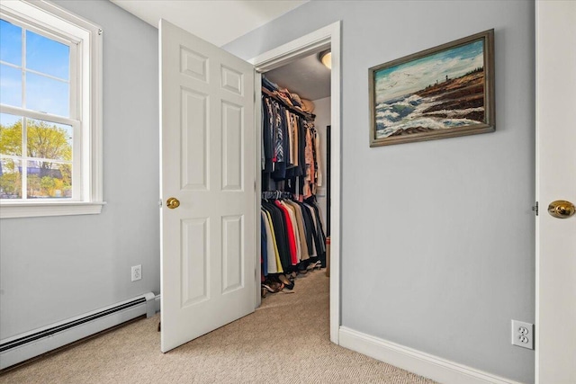 spacious closet featuring a baseboard radiator and light carpet