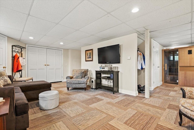 living area with a paneled ceiling, baseboards, light carpet, and recessed lighting