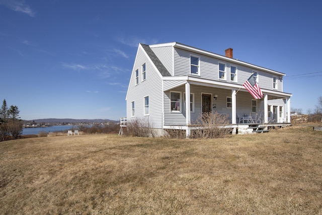 108 N Shore Dr, Owls Head, ME 04854 - view of front of home featuring covered porch, a chimney, and a front yard