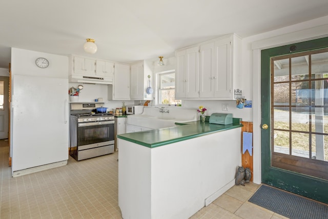 108 N Shore Dr, Owls Head, ME 04854 - kitchen with white cabinets, a peninsula, stainless steel gas range, under cabinet range hood, and white microwave