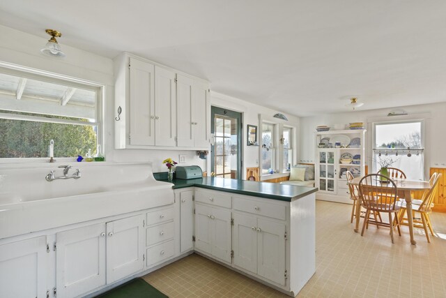 108 N Shore Dr, Owls Head, ME 04854 - kitchen with a wealth of natural light, white cabinets, and a peninsula