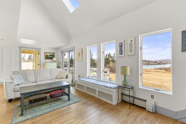 108 N Shore Dr, Owls Head, ME 04854 - living area with a healthy amount of sunlight, a baseboard radiator, a skylight, and wood-type flooring