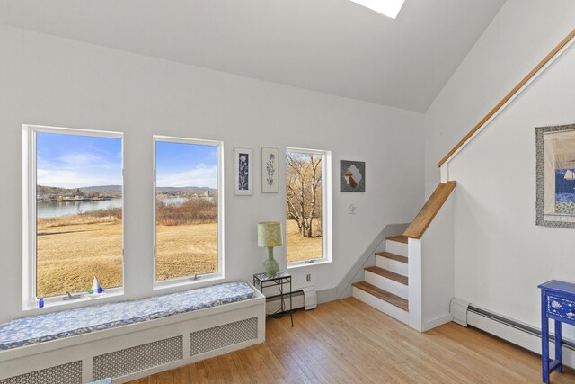 108 N Shore Dr, Owls Head, ME 04854 - living area featuring stairs, baseboard heating, light wood-style flooring, and radiator heating unit