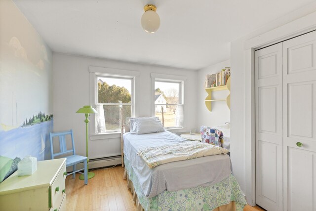 108 N Shore Dr, Owls Head, ME 04854 - bedroom featuring a baseboard radiator, a closet, and light wood-style flooring
