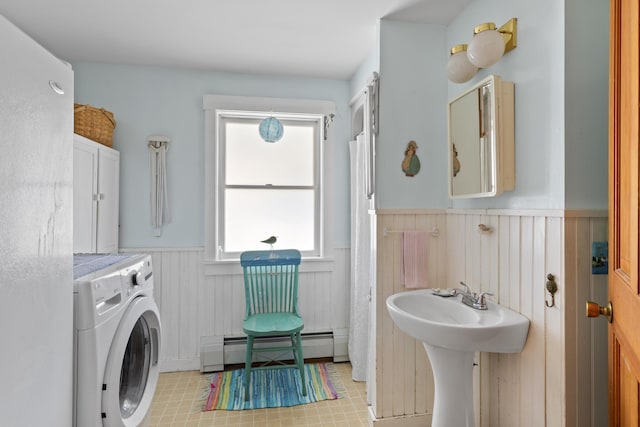 108 N Shore Dr, Owls Head, ME 04854 - clothes washing area with a wainscoted wall, a baseboard radiator, washer / clothes dryer, and laundry area