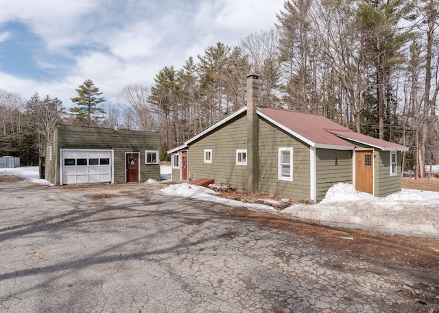 345 Songo Pond Rd, Bethel, ME 04217 - snow covered property featuring an outbuilding, driveway, a chimney, and a garage