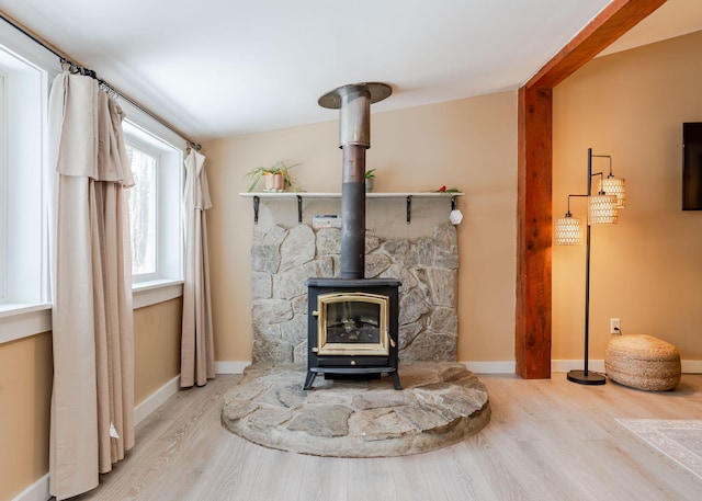 345 Songo Pond Rd, Bethel, ME 04217 - details with baseboards, wood finished floors, and a wood stove