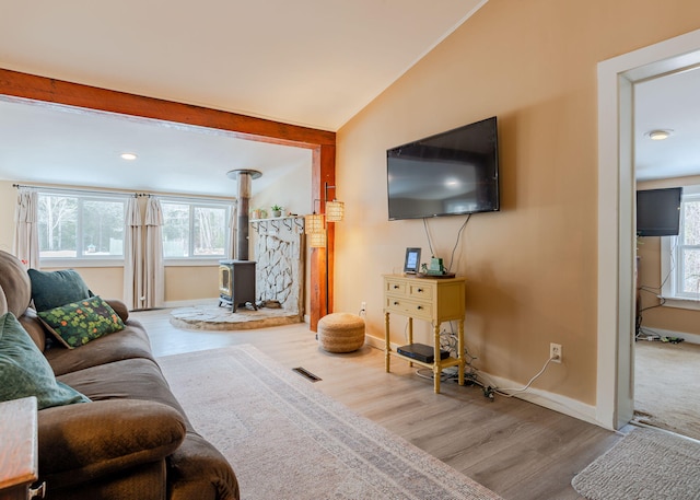 345 Songo Pond Rd, Bethel, ME 04217 - living room featuring visible vents, a healthy amount of sunlight, a wood stove, and wood finished floors