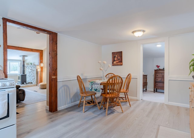 345 Songo Pond Rd, Bethel, ME 04217 - dining room with a wood stove, baseboards, and light wood finished floors