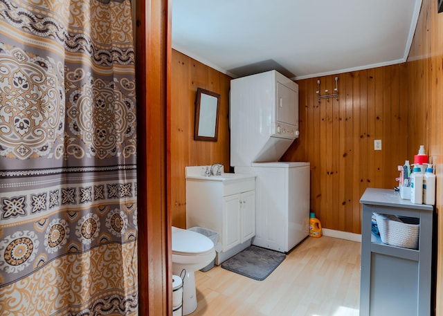 345 Songo Pond Rd, Bethel, ME 04217 - bathroom with toilet, wood finished floors, wooden walls, stacked washer / drying machine, and vanity