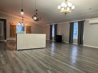 unfurnished living room with baseboards, a chandelier, a wall mounted AC, and dark wood-type flooring
