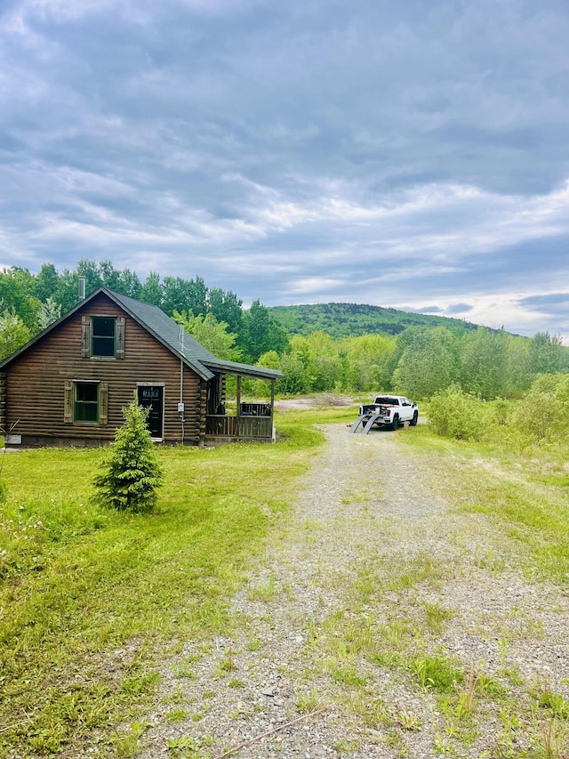 view of yard with a view of trees and driveway