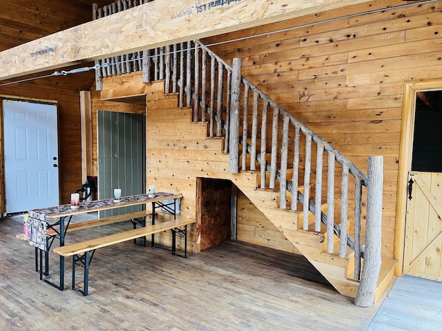 stairway featuring wooden walls and wood finished floors