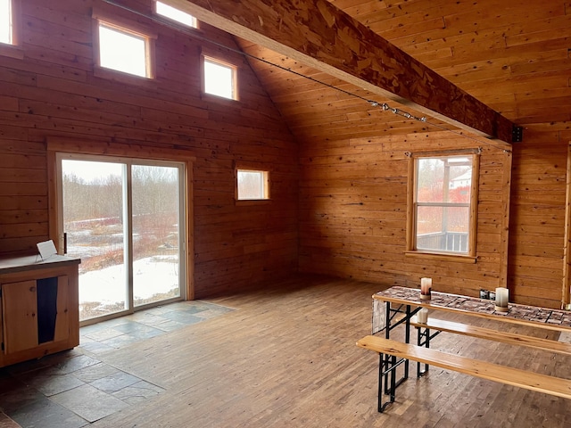 interior space featuring wooden ceiling, wooden walls, wood finished floors, and beam ceiling