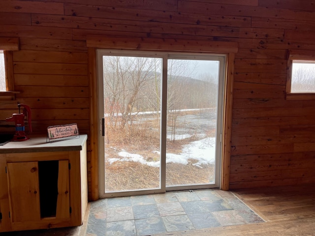 doorway to outside with wooden walls