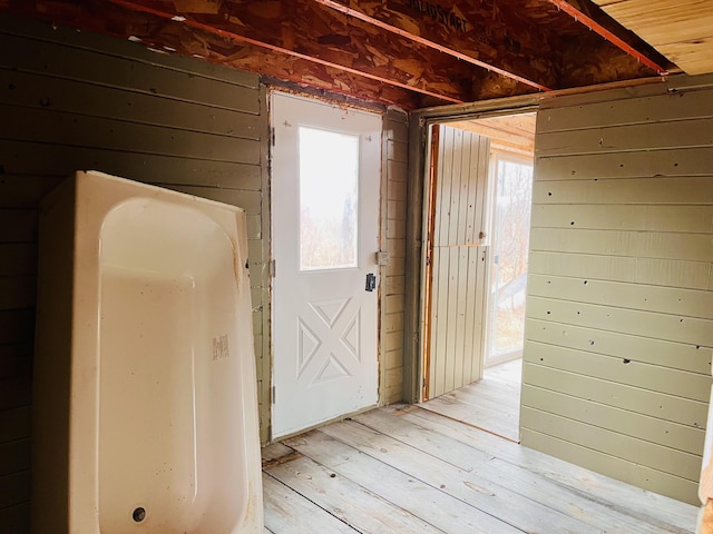 hall featuring wood walls and light wood finished floors