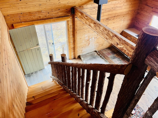 stairs with wood walls and hardwood / wood-style floors