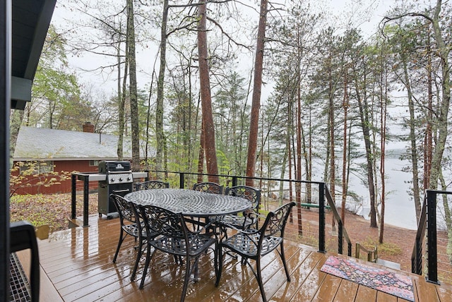 wooden terrace with outdoor dining space and grilling area