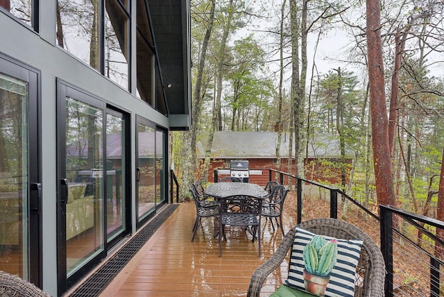 wooden deck featuring area for grilling and outdoor dining space