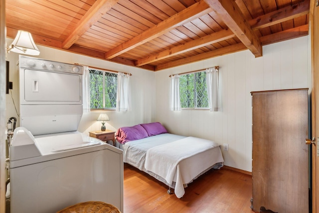 bedroom with multiple windows, light wood-style flooring, stacked washer / drying machine, and wooden ceiling