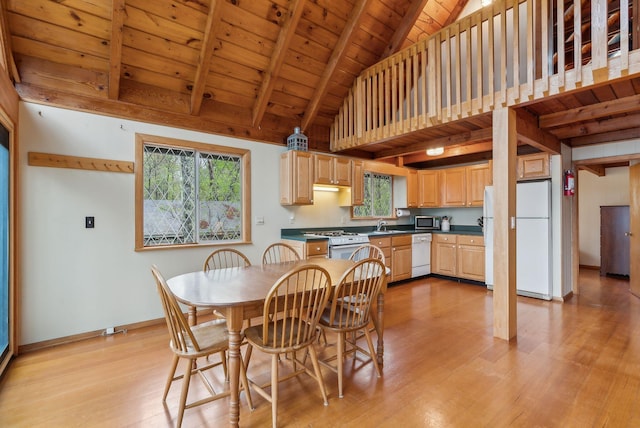 dining area with light wood-style flooring, high vaulted ceiling, beam ceiling, baseboards, and wooden ceiling