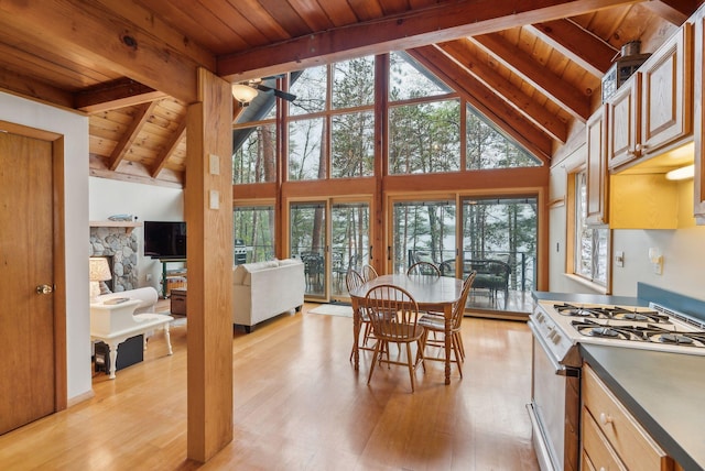 kitchen featuring white gas range oven, light wood-style flooring, a ceiling fan, wood ceiling, and vaulted ceiling with beams