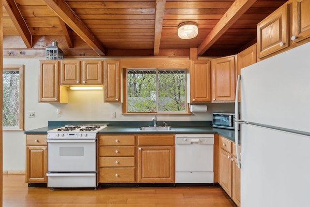 kitchen featuring light wood finished floors, a sink, beam ceiling, white appliances, and wooden ceiling