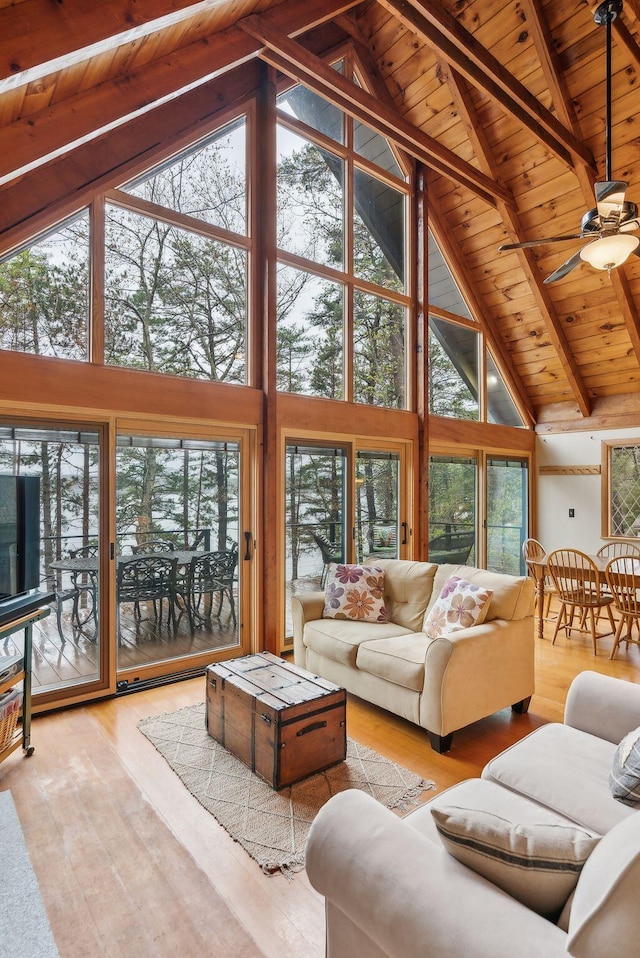 living area featuring wooden ceiling, high vaulted ceiling, and a healthy amount of sunlight