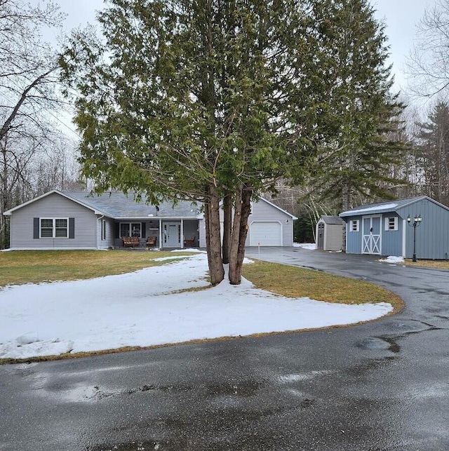 277 Grant Rd, Saint Albans, ME 04971 - ranch-style home with aphalt driveway, a yard, an outbuilding, and a detached garage