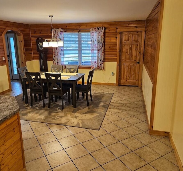 277 Grant Rd, Saint Albans, ME 04971 - dining room featuring wooden walls, light tile patterned floors, arched walkways, and a healthy amount of sunlight