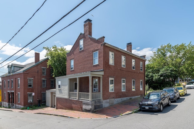 68 Pleasant St, Portland, ME 04101 - view of property exterior featuring brick siding, a chimney, and a porch