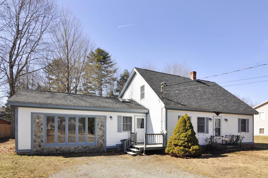view of front of house with a chimney and a shingled roof