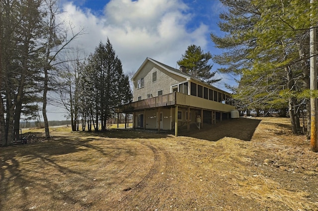 view of home's exterior with a sunroom, a deck, and a chimney