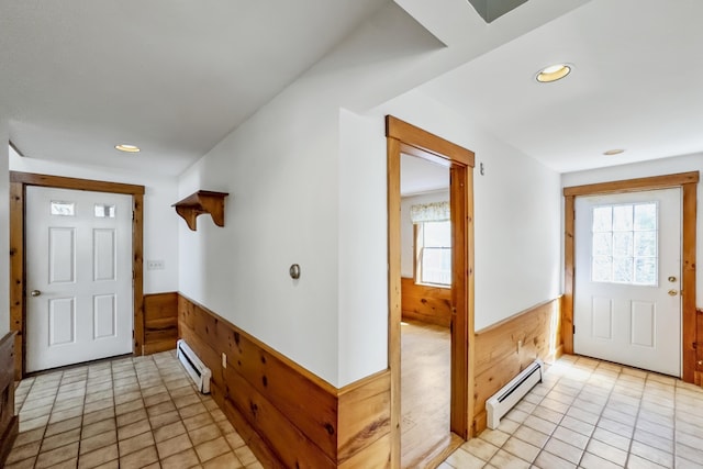 foyer entrance featuring recessed lighting, wooden walls, baseboard heating, and wainscoting
