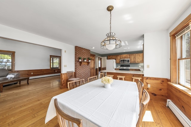 dining room with light wood-style flooring, a baseboard radiator, and plenty of natural light