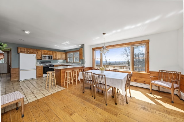dining room with recessed lighting, wainscoting, and light wood-style floors