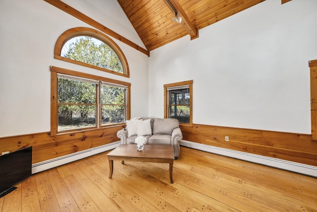 living area featuring baseboard heating, wood ceiling, hardwood / wood-style floors, and a wealth of natural light